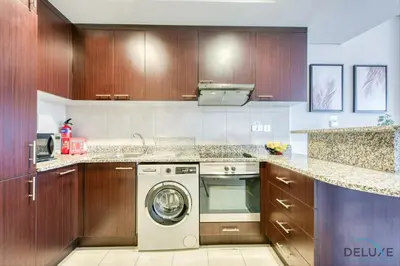 a kitchen with a washer and a dishwasher at Calm Studio at Sky Gardens DIFC by Deluxe Holiday Homes in Dubai