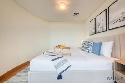 a bedroom with a white bed and a table at Oceanic Studio at Sky Gardens DIFC by Deluxe Holiday Homes in Dubai