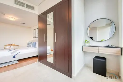 a bedroom with a sliding door and a mirror at Oceanic Studio at Sky Gardens DIFC by Deluxe Holiday Homes in Dubai