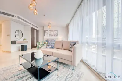 a living room with a couch and a table at Tranquil Studio at Sky Gardens DIFC by Deluxe Holiday Homes in Dubai