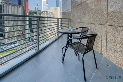a table and chair on the balcony of a building at Tranquil Studio at Sky Gardens DIFC by Deluxe Holiday Homes in Dubai