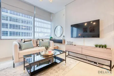 a living room with a couch and a tv at Radiant Studio at Sky Gardens DIFC by Deluxe Holiday Homes in Dubai