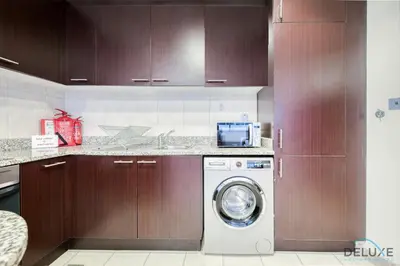 a kitchen with a washing machine in a kitchen at Radiant Studio at Sky Gardens DIFC by Deluxe Holiday Homes in Dubai