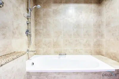 a bathroom with a white tub and a shower at Radiant Studio at Sky Gardens DIFC by Deluxe Holiday Homes in Dubai