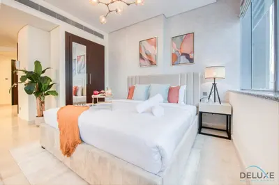 a bedroom with a large white bed and a window at Radiant Studio at Sky Gardens DIFC by Deluxe Holiday Homes in Dubai