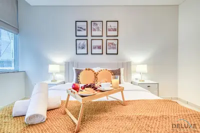a bedroom with a bed with a tray of food on it at Gorgeous 1BR at Sky Gardens, DIFC by Deluxe Holiday Homes in Dubai