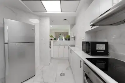 a white kitchen with a microwave and a refrigerator at Marco Polo - Your luxurious high-floor escape in Dubai Marina in Dubai