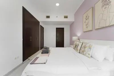 a bedroom with a large bed with white sheets and pillows at Marco Polo - Your luxurious high-floor escape in Dubai Marina in Dubai