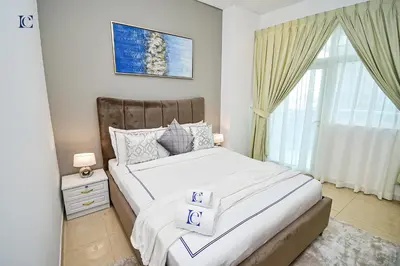 a bedroom with a large bed and a window at Luxury Escapes - Budget Studio with Balcony, Yacht Bay Marina in Dubai