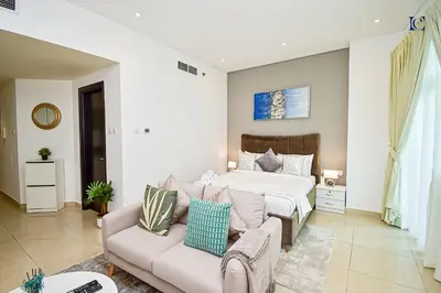 a bedroom with a bed and a couch at Luxury Escapes - Budget Studio with Balcony, Yacht Bay Marina in Dubai