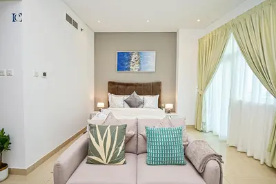 a bedroom with a bed and a couch at Luxury Escapes - Budget Studio with Balcony, Yacht Bay Marina in Dubai
