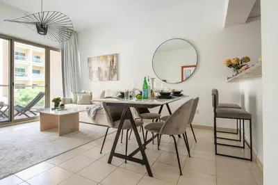 a dining room with a table and a mirror at Frank Porter - Al Thayyal 2, The Greens in Dubai