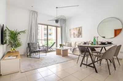 a living room with a table and chairs at Frank Porter - Al Thayyal 2, The Greens in Dubai