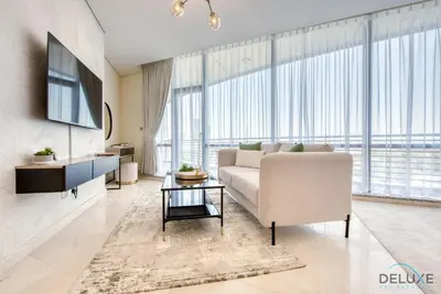 a living room with a couch and a large window at Upscale Studio at Sky Gardens DIFC by Deluxe Holiday Homes in Dubai