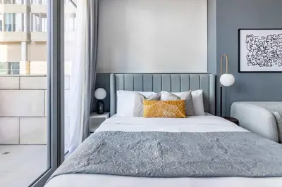 a bedroom with a large bed with orange pillows at Silkhaus comfy furnished studio in the heart of DIFC in Dubai