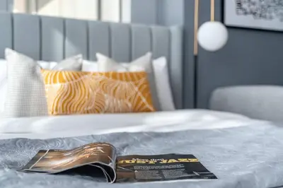 a bed with a book and pillows on it at Silkhaus comfy furnished studio in the heart of DIFC in Dubai