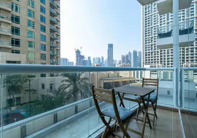 a table and chairs on a balcony with a view of a city at RH-City Retreat, 01 BR, near Burj Khalifa Downtown in Dubai