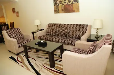 a living room with a couch and two chairs at Ivory Grand Hotel Apartments in Dubai