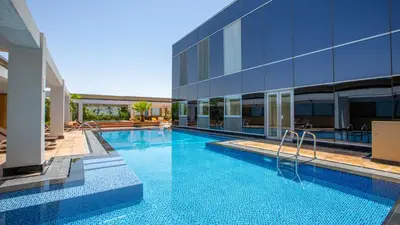 a swimming pool in front of a building at Sleek Studio at Sky Gardens DIFC by Deluxe Holiday Homes in Dubai