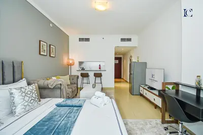a bedroom with a bed and a living room at Luxury Escapes - Modern Studio near Metro in X1 Tower JLT in Dubai