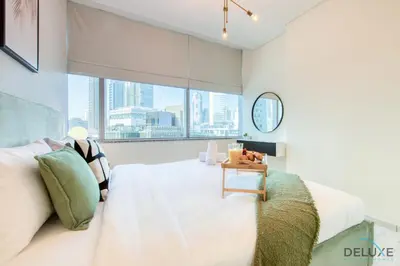 a bedroom with a bed with a view of the city at Best Deal Elegant Studio with Balcony & Prime Location by Deluxe Holiday Homes in Dubai