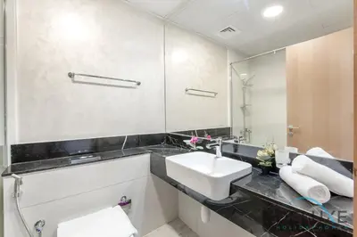 a bathroom with a sink and a mirror at Intimate Studio at Millennium Binghatti Residence Business Bay by Deluxe Holiday Homes in Dubai