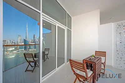a room with a table and chairs on a balcony at Intimate Studio at Millennium Binghatti Residence Business Bay by Deluxe Holiday Homes in Dubai