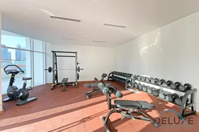 a gym with several treadmills and exercise bikes at Intimate Studio at Millennium Binghatti Residence Business Bay by Deluxe Holiday Homes in Dubai