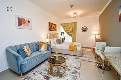 a living room with a blue couch and a bed at Luxury Escapes - Cozy Studio - Goldcrest Executives JLT in Dubai