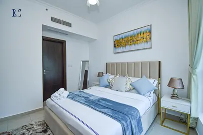 a bedroom with a large white bed with blue pillows at Luxury Escapes - Marina Views 1BR Apartments - Bay Central Dubai Marina in Dubai