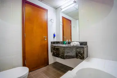 a bathroom with a sink and a wooden door at RH- Urban Living, Studio near Dubai Mall, Downtown in Dubai