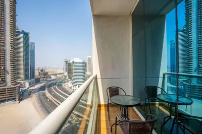 a balcony with tables and chairs and a view of a city at RH- Urban Living, Studio near Dubai Mall, Downtown in Dubai