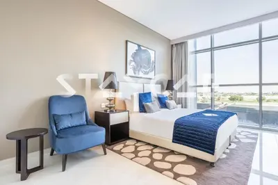 a bedroom with a bed and a blue chair at Staycae Holiday Homes - Artesia in Dubai