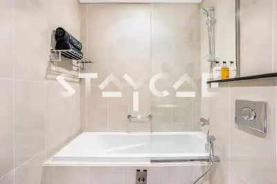 a bath tub in a bathroom with a shower at Staycae Holiday Homes - Artesia in Dubai