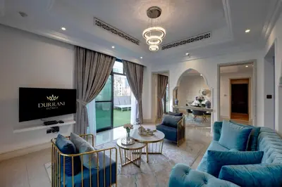 a living room with blue couches and a tv at Durrani Homes - Unique Garden Apt at Souk Al Bahar besides Dubai Mall & Burjkhalifa with private jaccuzi in Dubai