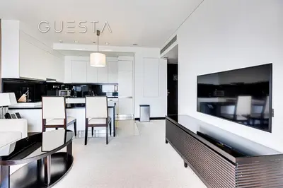 a living room with a kitchen with a large tv at Marina Mall Apartments, Dubai Marina in Dubai