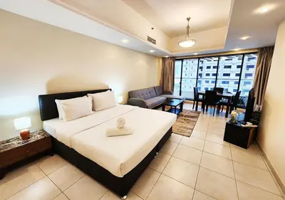 a hotel room with a bed and a dining room at RH- Cozy Studio, Al Waleed , Cluster R, JLT in Dubai