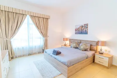 a bedroom with a bed and a large window at Luxury Escapes - Spacious 2BR Apt in the heart of Dubai Marina- Yacht Bay in Dubai