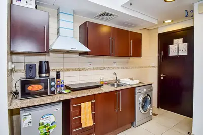 a kitchen with a sink and a dishwasher at Luxury Escapes - Modern Studio Apt - Metro, Beach & Mall mins away in Dubai