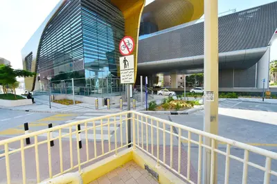a building with a white railing next to a street at Luxury Escapes - Spacious Fully Furnished Studio Apt - Next to Metro, 5 Mins from Mall - MED46 in Dubai