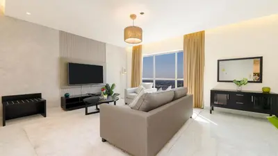 a living room with a couch and a television at Regent Sea View 2BR Apartment JBR Beach Walk - next to Bluewater Island & Dubai Eye in Dubai
