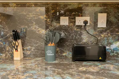 a cup with utensils in it next to a microwave at Regent Sea View 2BR Apartment JBR Beach Walk - next to Bluewater Island & Dubai Eye in Dubai