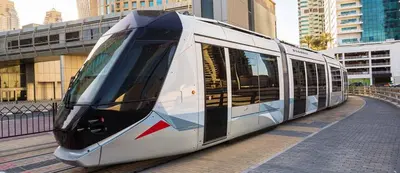 a train on the tracks in a city at Regent Sea View 2BR Apartment JBR Beach Walk - next to Bluewater Island & Dubai Eye in Dubai