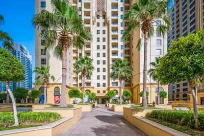 a city street with palm trees and buildings at Lovely 2-bed condo in JBR - 5 mins from beach - Palm View! in Dubai