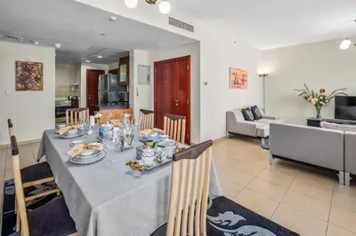 a dining room with a table and chairs and a kitchen at Lovely 2-bed condo in JBR - 5 mins from beach - Palm View! in Dubai