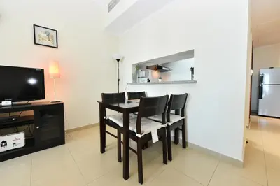 a dining room with a table and chairs and a television at Luxury Escapes - Studio in JLT X1 Tower close to Metro in Dubai