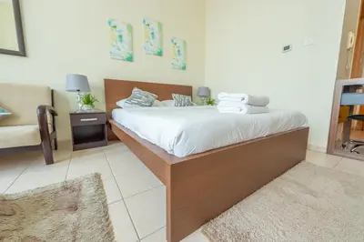 a bedroom with a bed and a couch at Luxury Escapes - Budget Studio Apt near Metro Stn - MOG184 DG in Dubai