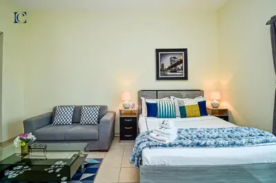 a bedroom with a bed and a chair and a couch at Luxury Escapes - Cozy budget studio near Metro & Ibn Battuta Mall - MOG190 DG in Dubai