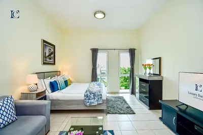 a living room with a bed and a tv at Luxury Escapes - Cozy budget studio near Metro & Ibn Battuta Mall - MOG190 DG in Dubai