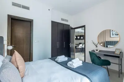 a bedroom with a bed with a desk and a mirror at GuestReady - Elegant 1BR w/ Balcony | Dubai Marina in Dubai